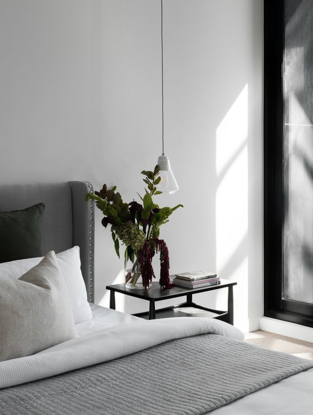 a bed with a tree on a bedside table