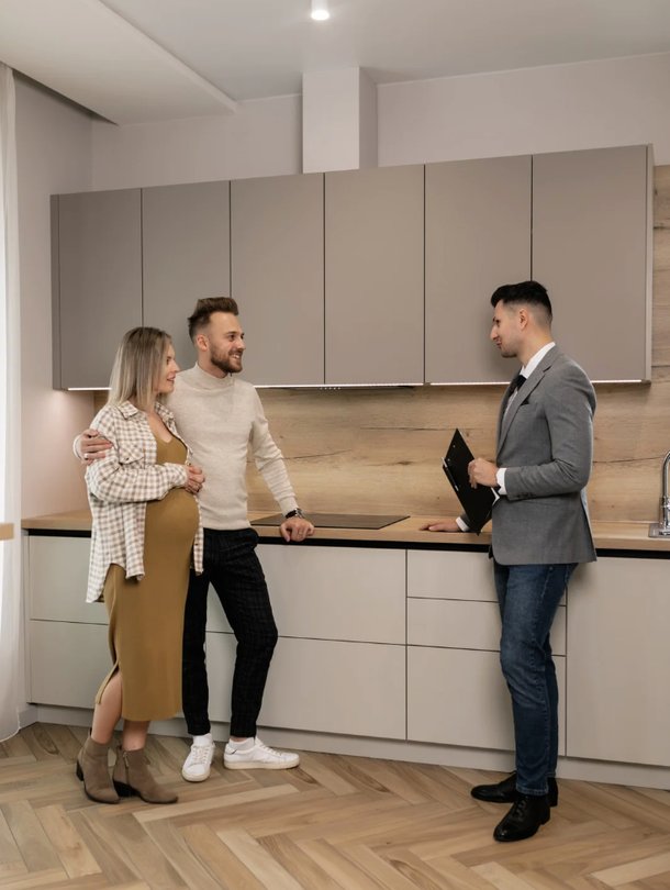 a short-term letting agent shows a kitchen off to prospective clients