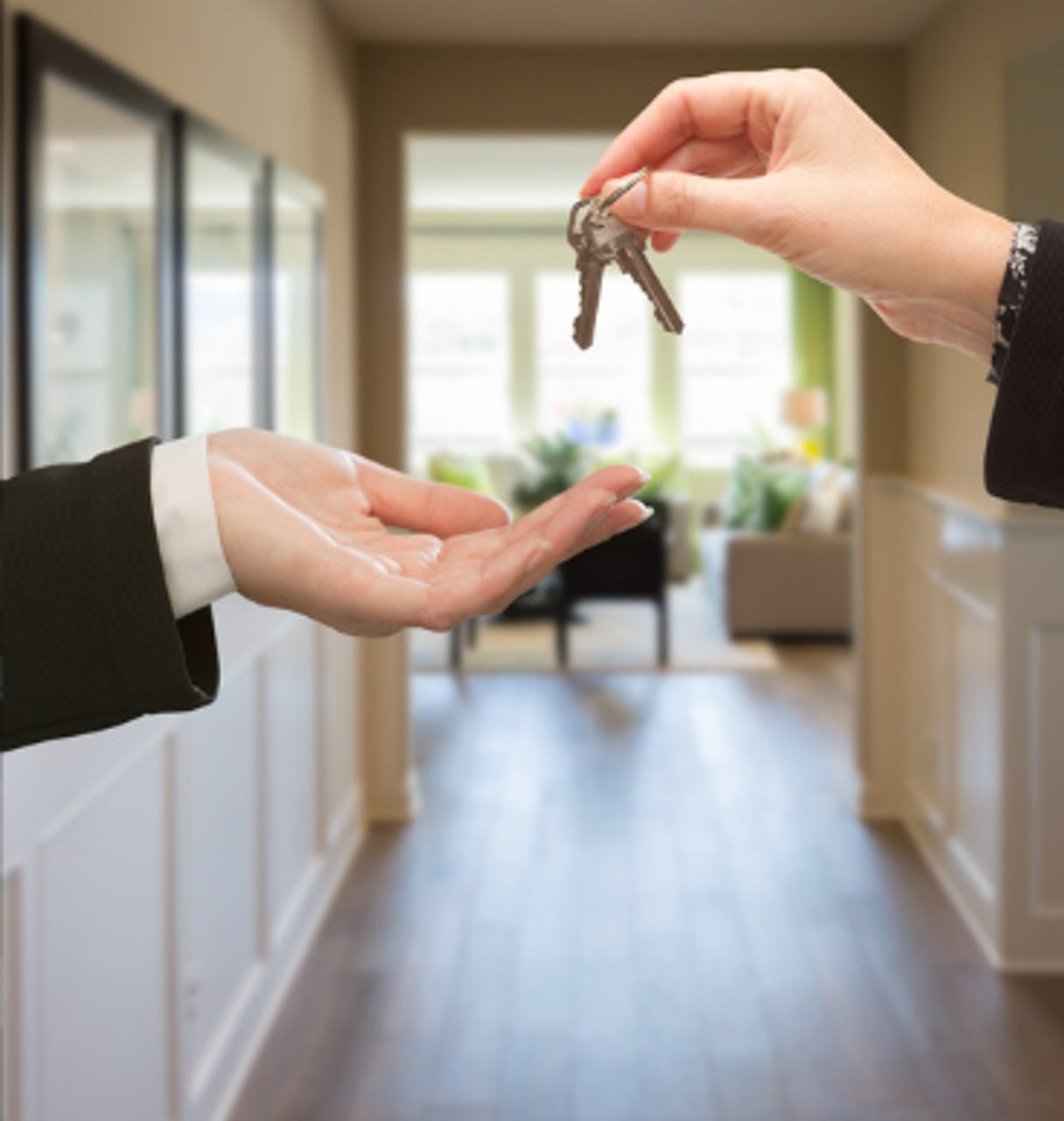 two pairs of hands exchanging keys