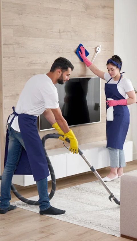 two cleaners hoover and polish a living room
